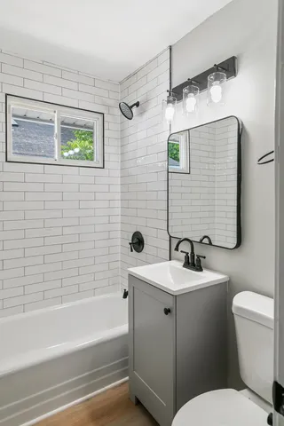 a bathroom with a sink a toilet and shower