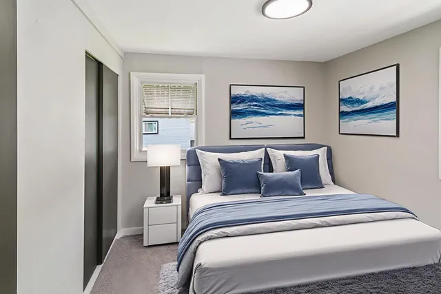 a bedroom with a large bed and a painting on the wall