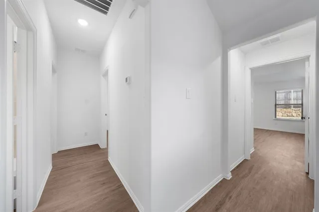 a view of a hallway with wooden floor