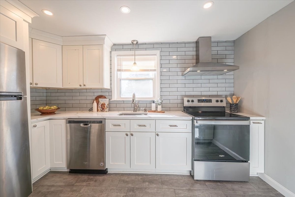33 Kensington Road Dedham, MA 02026 - Photo 11 of 31 a kitchen with a sink stove and cabinets