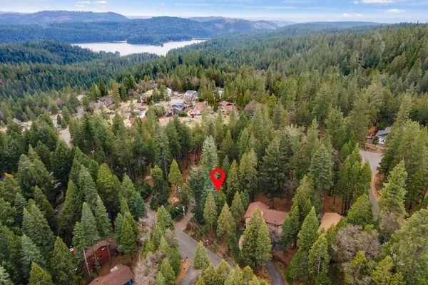 an aerial view of residential house with outdoor space and trees all around