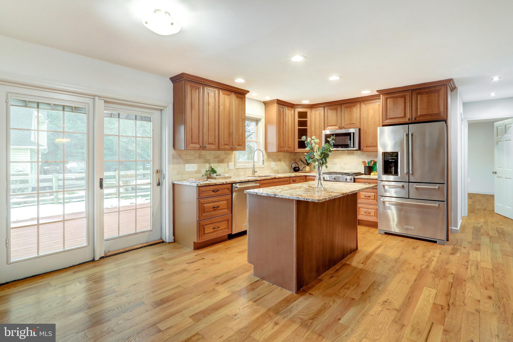 152 Kings Gate Drive Lititz, PA 17543 - Photo 8 of 45 a kitchen with kitchen island granite countertop wooden floors stainless steel appliances a sink and a window