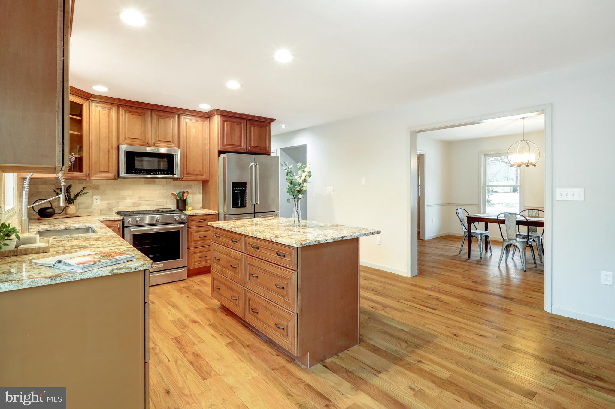 152 Kings Gate Drive Lititz, PA 17543 - Photo 10 of 45 a kitchen with stainless steel appliances granite countertop wooden cabinets a sink a stove a dining table and chairs