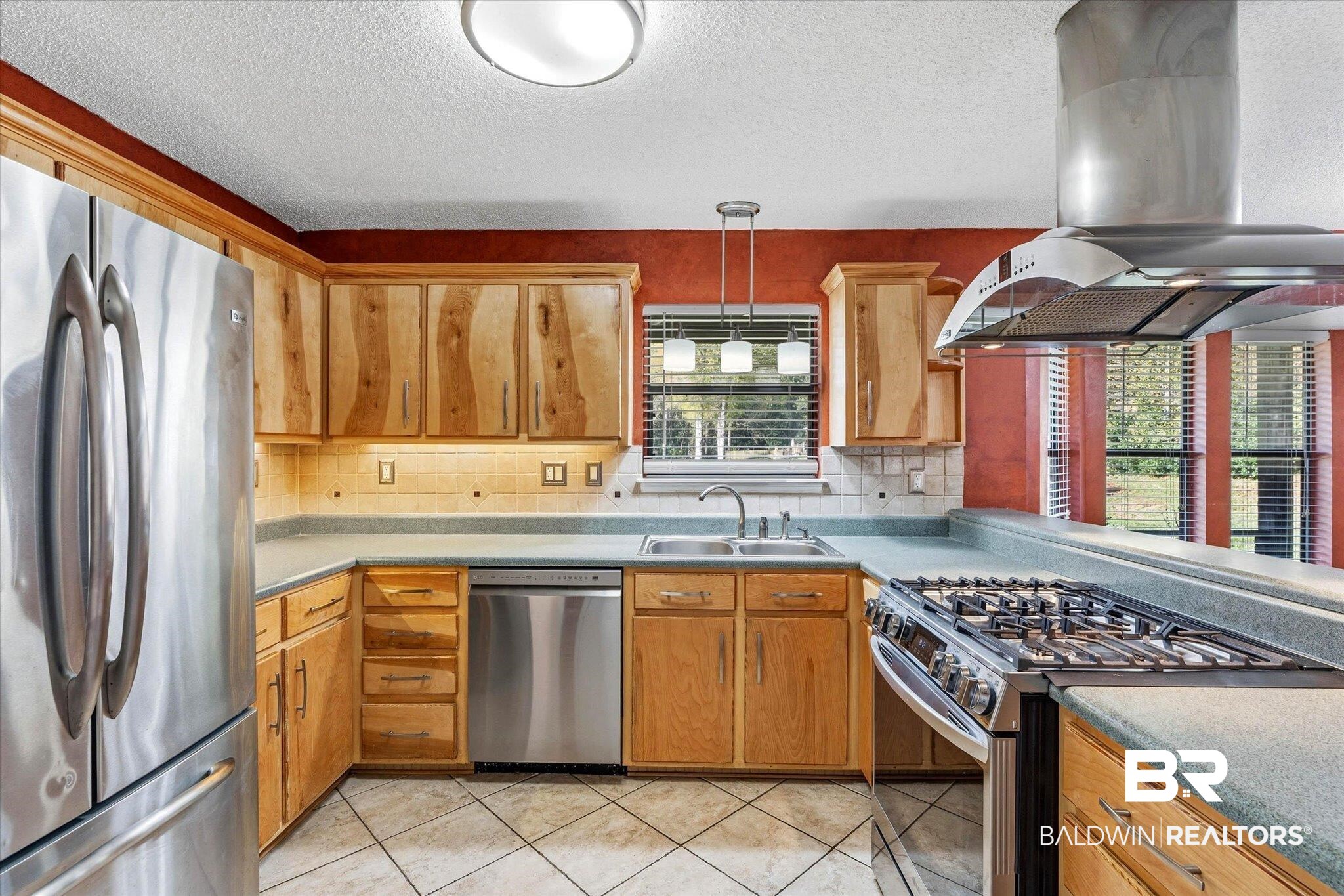 8030 Country Drive Mobile, AL 36619 - Photo 7 of 22 Kitchen featuring stainless steel appliances, island exhaust hood, decorative light fixtures, light tile patterned floors, and a textured ceiling