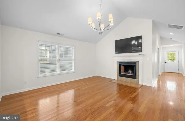 a view of empty room with wooden floor and fireplace