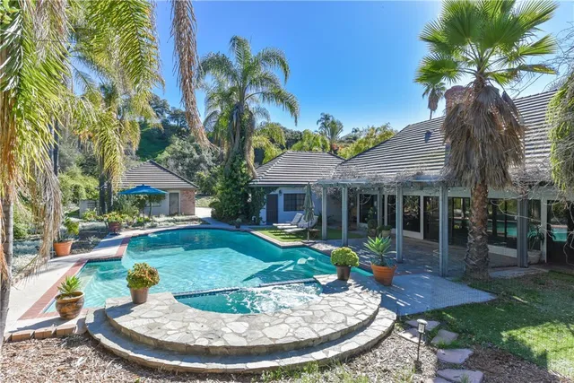 a view of a house with palm tree and a small yard