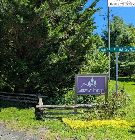 a sign that is sitting in front of a tree
