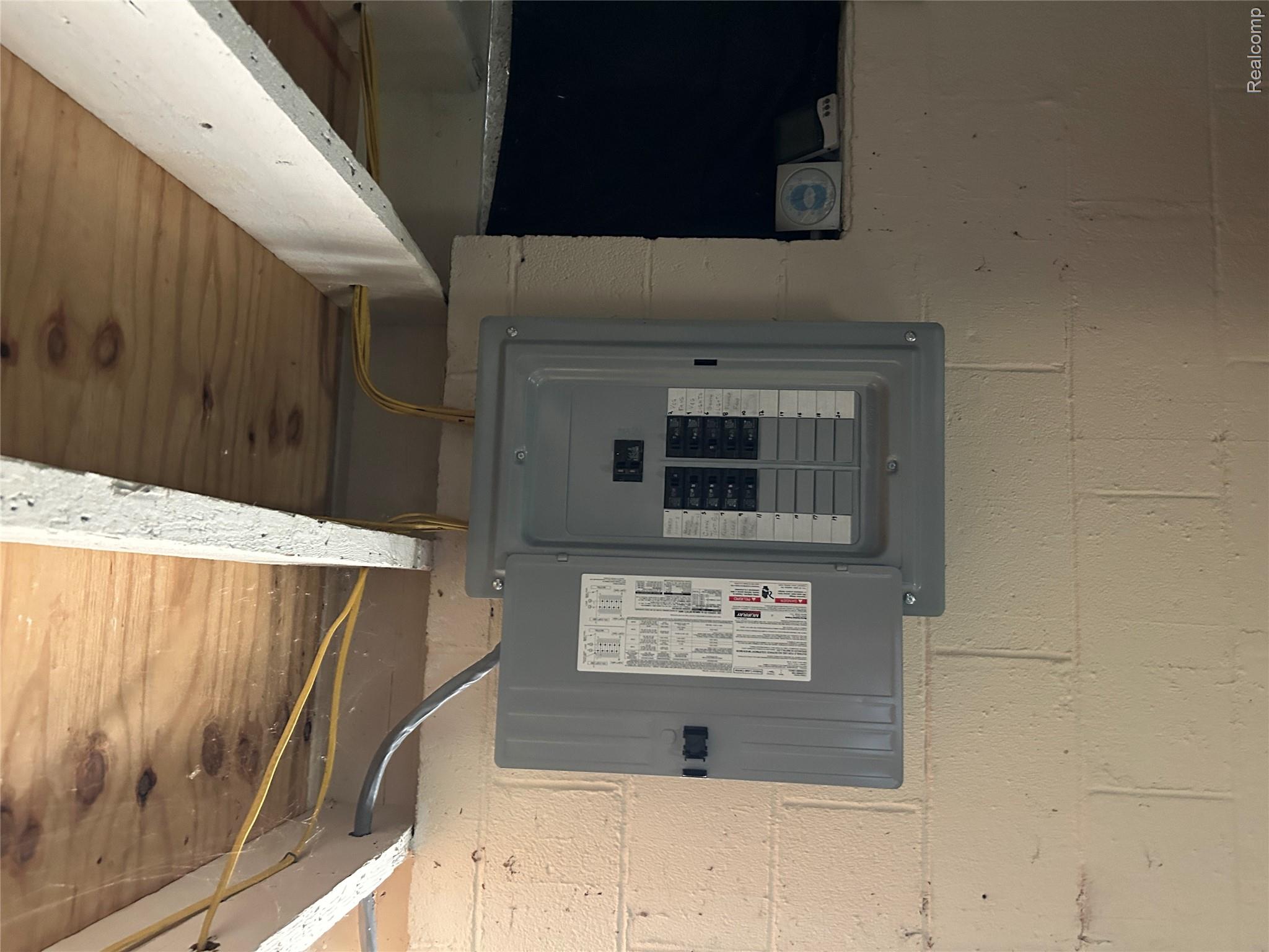 16465 Almont Road Allenton, MI 48002 - Photo 22 of 35 Electrical panel installed on a painted concrete block wall