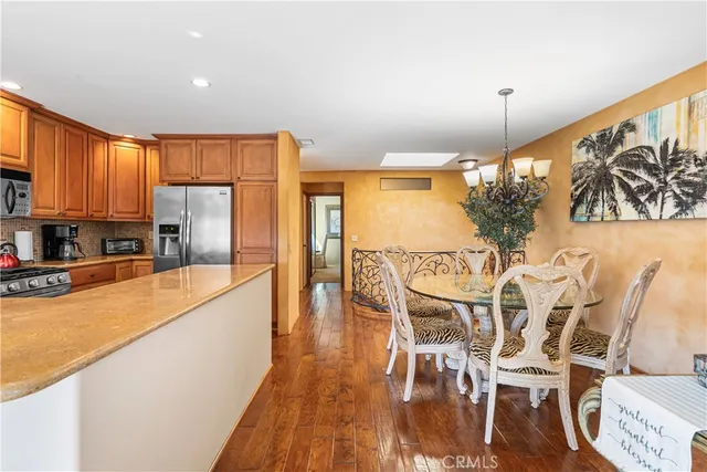 a kitchen with granite countertop a table chairs stove and refrigerator