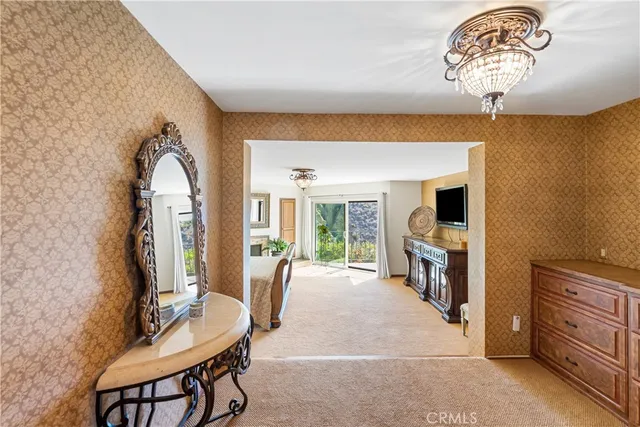 a spacious bedroom with a bed a mirror on dresser and a large window