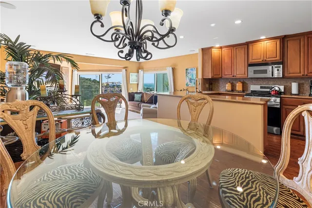 a kitchen with stainless steel appliances granite countertop a sink a table and chairs