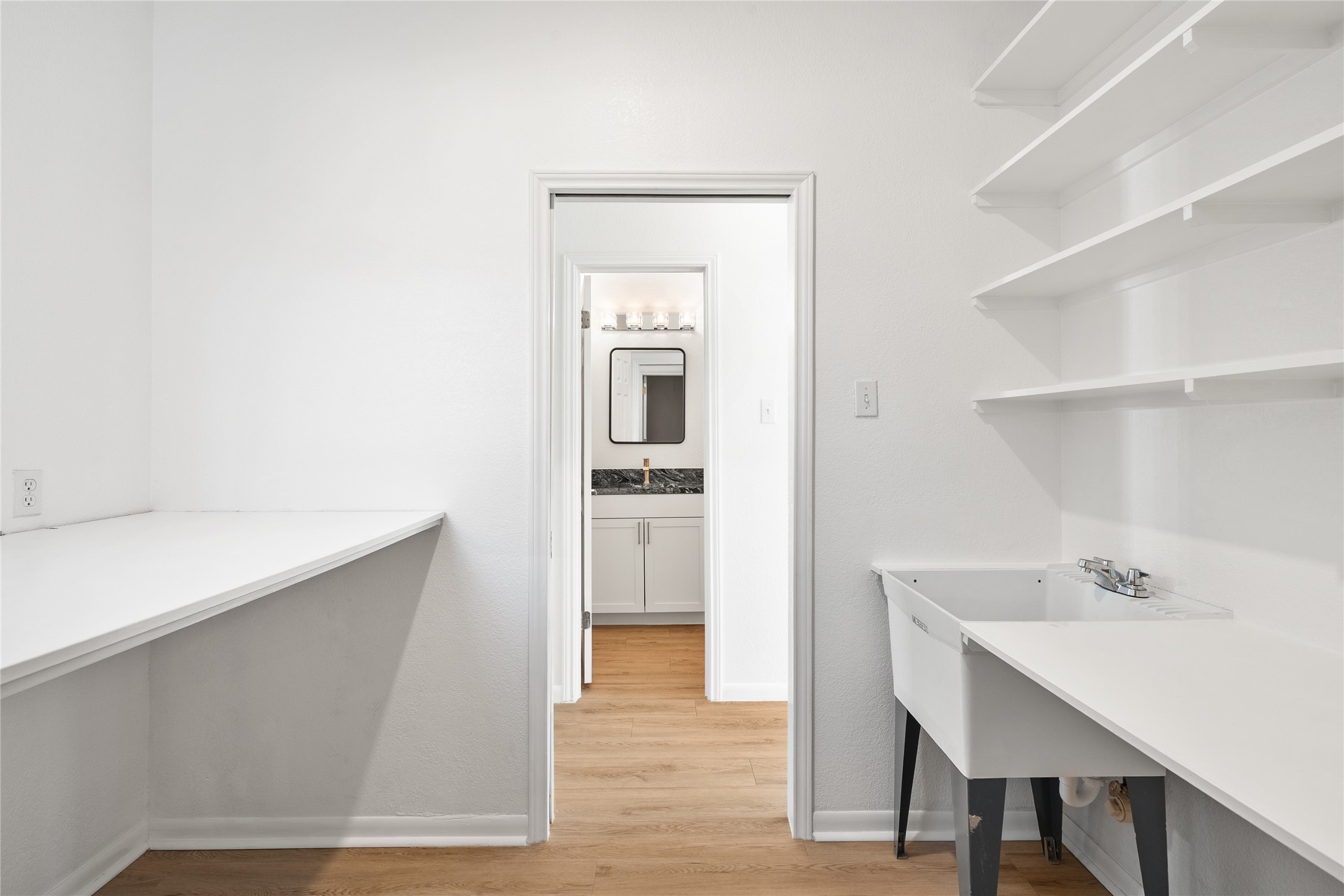 206 River Down Road Georgetown, TX 78628 - Photo 21 of 39 Utility room featuring a built-in sink, extensive white shelving, and a long white countertop