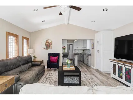 a living room with furniture a large window and a chandelier