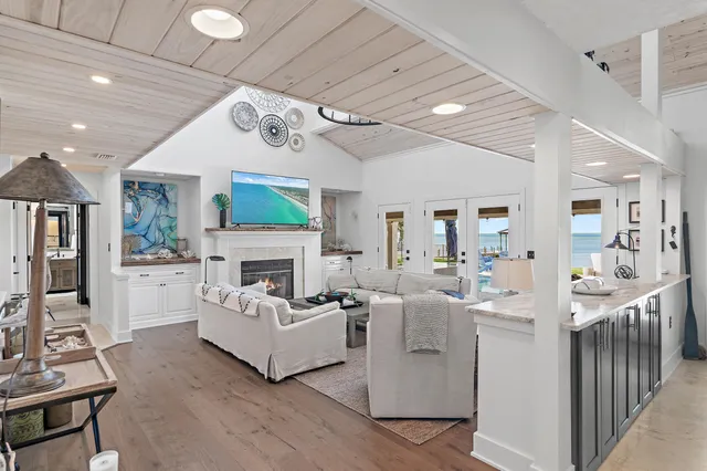 a view of a dining room and livingroom with furniture wooden floor a chandelier