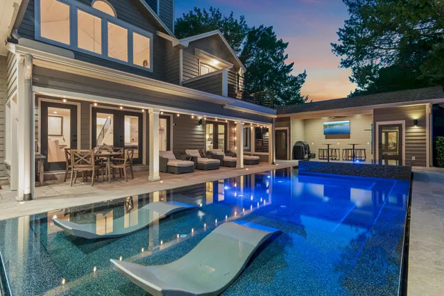 a view of a house with pool and chairs