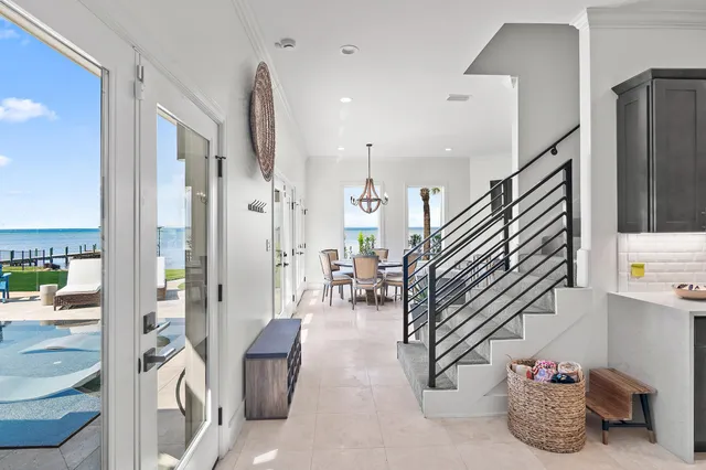 a view of a patio with couches table and chairs under an umbrella with large trees