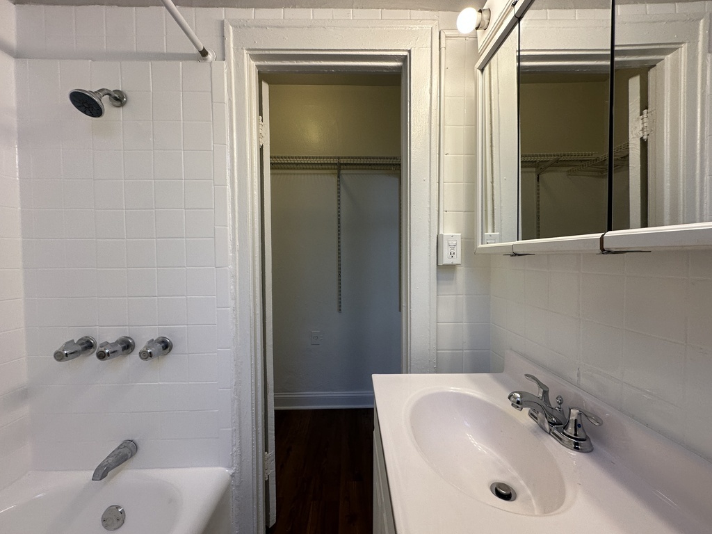 661 West Sheridan Road, Unit 208 Chicago, IL 60613 - Photo 19 of 20 a bathroom with a tub a sink and mirror