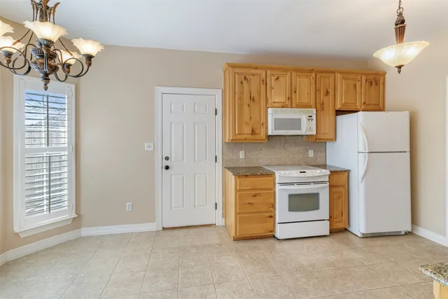 a kitchen with stainless steel appliances granite countertop a refrigerator a stove a microwave oven with white cabinets