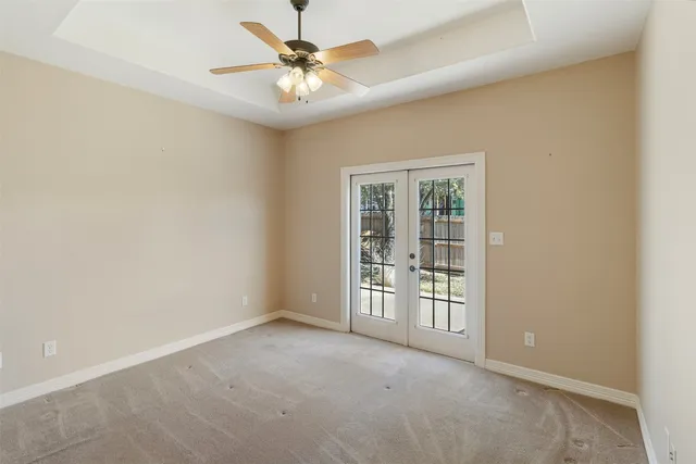 an empty room with windows and fan