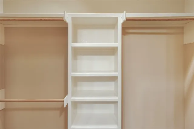 a view of walk in closet with empty racks