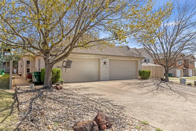 a front view of a house with a yard and trees