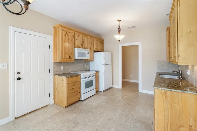 a kitchen with stainless steel appliances granite countertop a stove a sink and a refrigerator