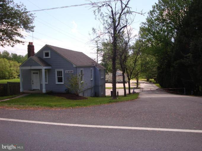 a front view of a house with a garden and trees