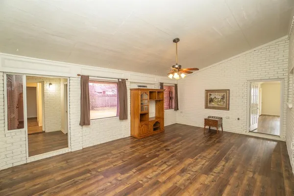 a view of a livingroom with wooden floor and a ceiling fan