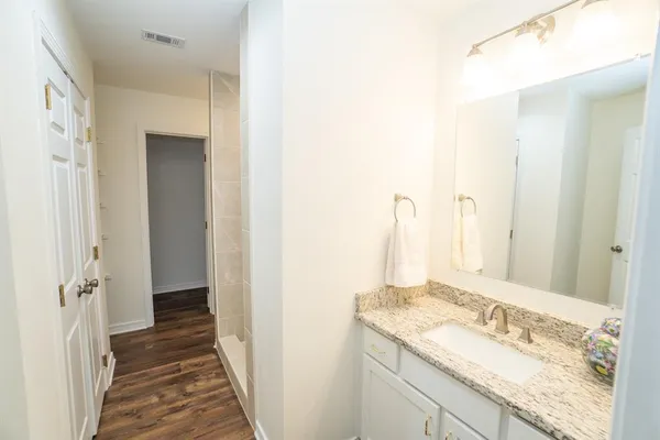 a bathroom with a granite countertop sink and a mirror