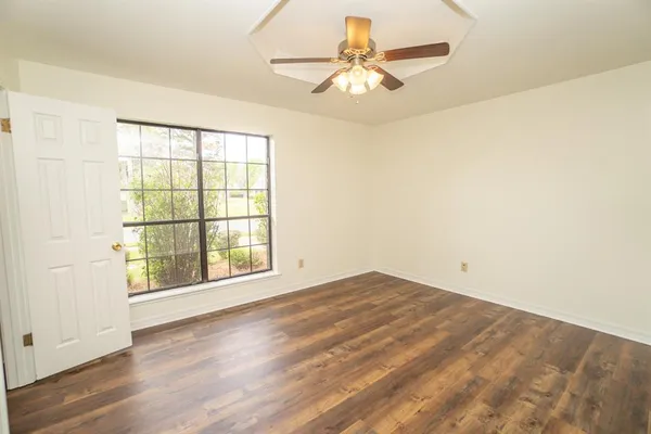 wooden floor in an empty room with a window