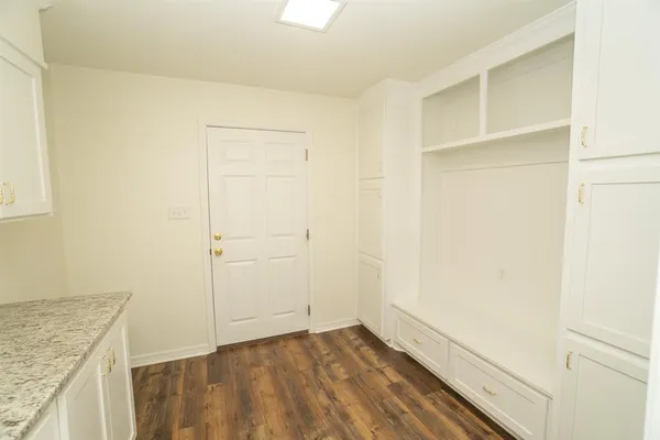 a view of an empty room with wooden floor and closet