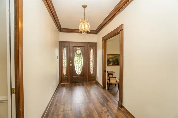 a view of a room with wooden floor chandeliers and staircase