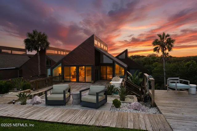 a view of roof deck with table and chairs a barbeque with wooden floor and fence