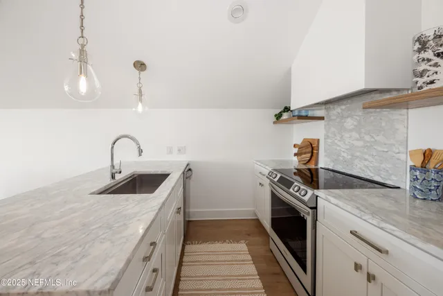 a kitchen with sink a stove and oven