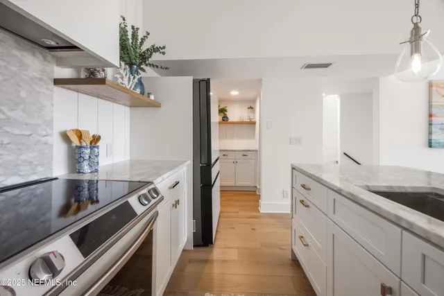 a kitchen with sink a stove and cabinets