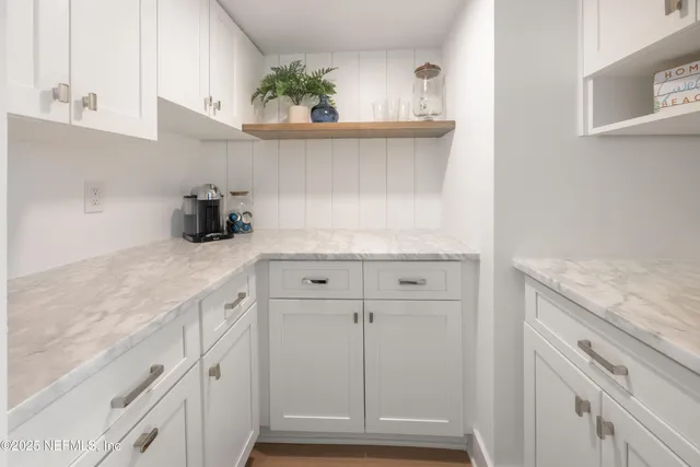 a kitchen with granite countertop white cabinets and a sink