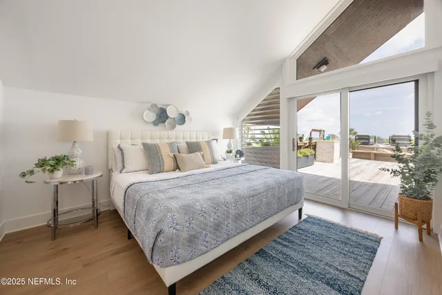 a bedroom with a large bed and a potted plant on the dresser