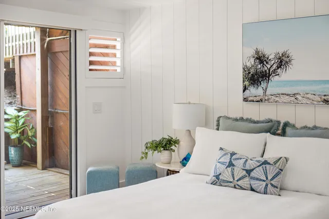 a bedroom with a bed and a potted plant