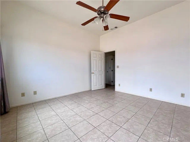 an empty room with chandelier fan