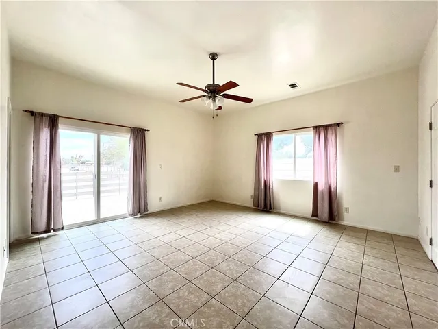 a view of a livingroom with a chandelier fan and windows
