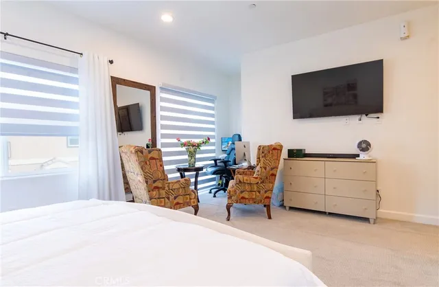 a bedroom with furniture and a flat screen tv