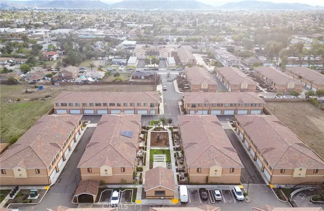 an aerial view of residential houses with outdoor space and parking
