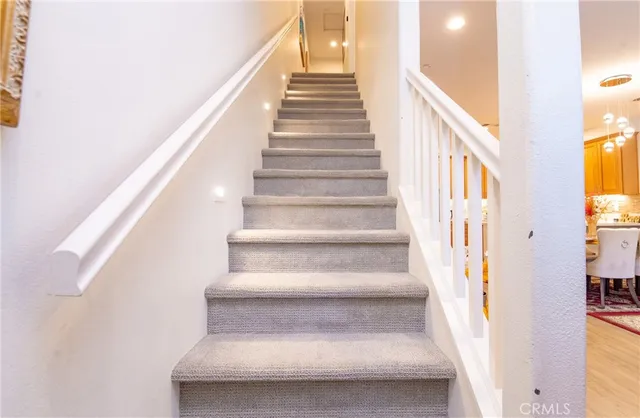 a view of staircase with lots of frames on wall and a large window