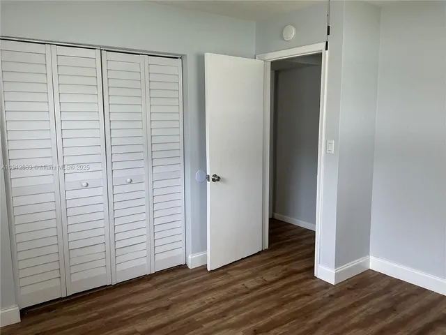 an empty room with wooden floor and closet