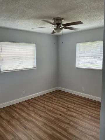 a view of a room with wooden floor and fan