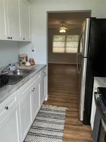 a kitchen with a sink a refrigerator and cabinets
