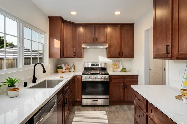 a kitchen with kitchen island granite countertop a sink stainless steel appliances and cabinets