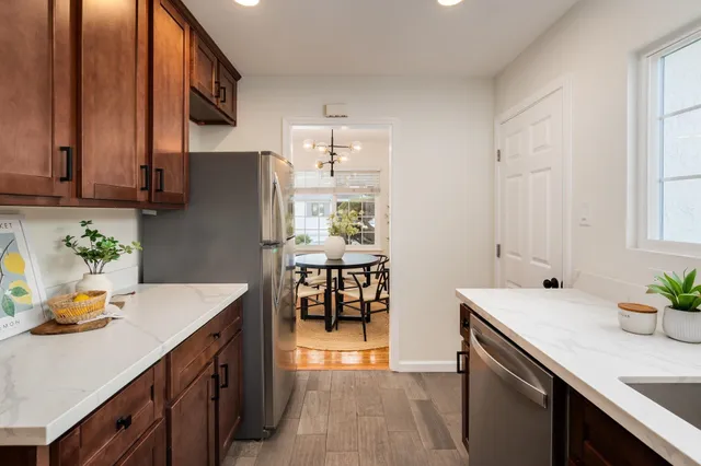 a kitchen with stainless steel appliances a sink a refrigerator and a refrigerator