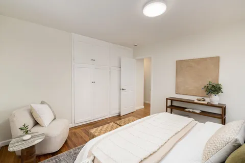 a bedroom with a bed and a potted plant