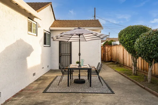 a view of a patio with table and chairs with wooden fence